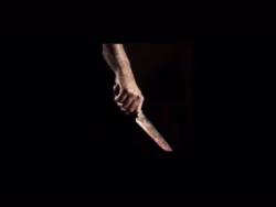 Na imagem Ilustrativa Braço de homem segurando a faca no escuro.