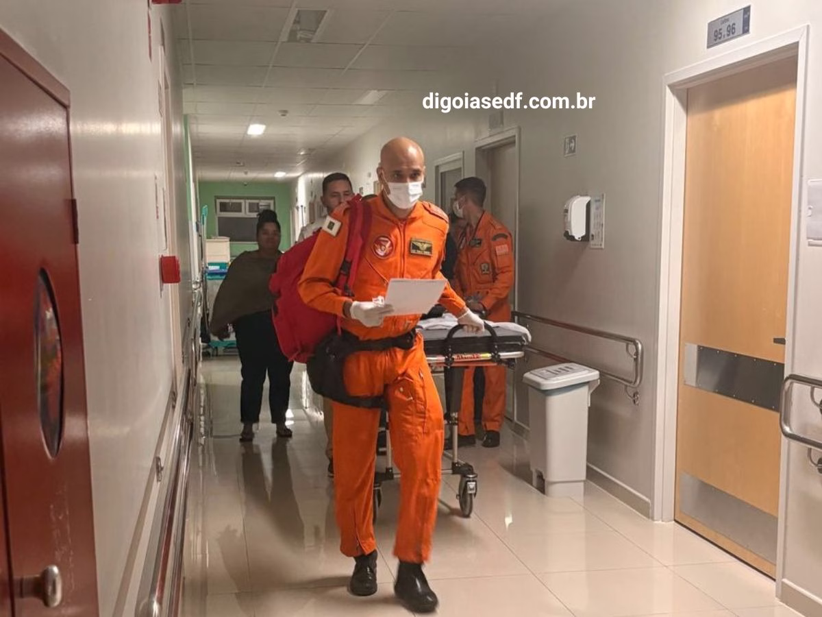 Bombeiros e médicos puxando a maçã com criança em hospital para transplante.