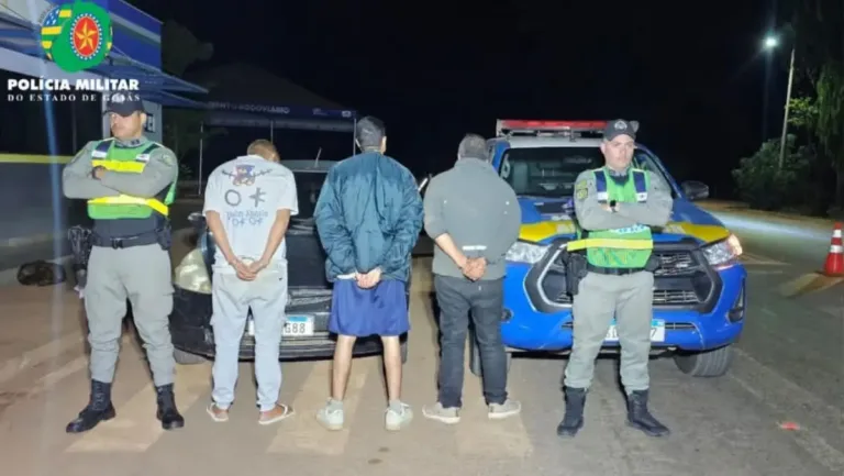 Homens presos na GO 118, em Alto Paraíso, na foto três homens de costas e policiais em pé de frente para a câmera.