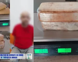Homem preso com drogas durante viagem com carro de aplicativo, homem ao lado dos tabletes de drogas apreendidas.