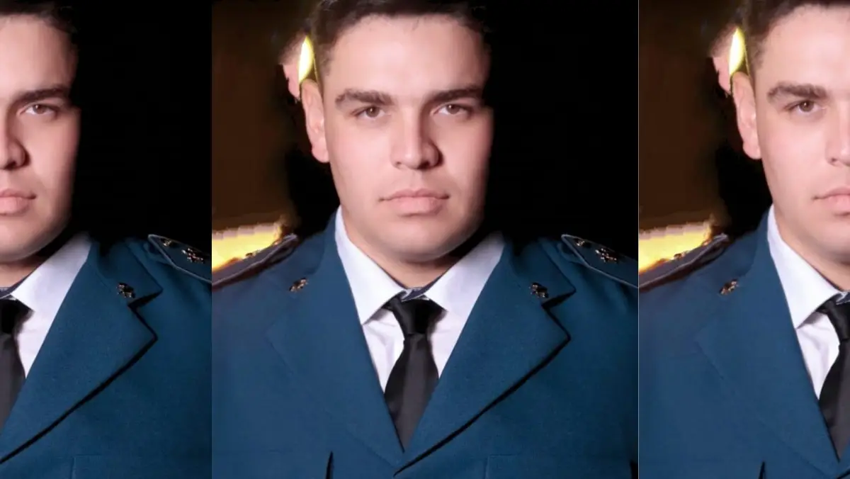 Montagem fotográfica repetindo o mesmo homem em três seções verticais lado a lado. Ele aparece em um retrato formal de estúdio, com uma expressão séria, olhando diretamente para a câmera. Está vestindo uma farda oficial azul-petróleo de gala, camisa social branca por baixo e uma gravata preta escura. O fundo é escuro.