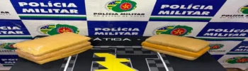 Drogas apreendidas na BR-020 em Formosa, a força tática fez a abordagem e encontrou a droga, na imagem está sobre a mesa com banner ao fundo escrito Polícia Militar.