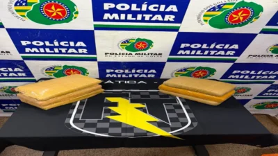Tráfico de drogas na BR 020: Força Tática apreende tabletes de maconha 1 Drogas apreendidas na BR-020 em Formosa, a força tática fez a abordagem e encontrou a droga, na imagem está sobre a mesa com banner ao fundo escrito Polícia Militar.