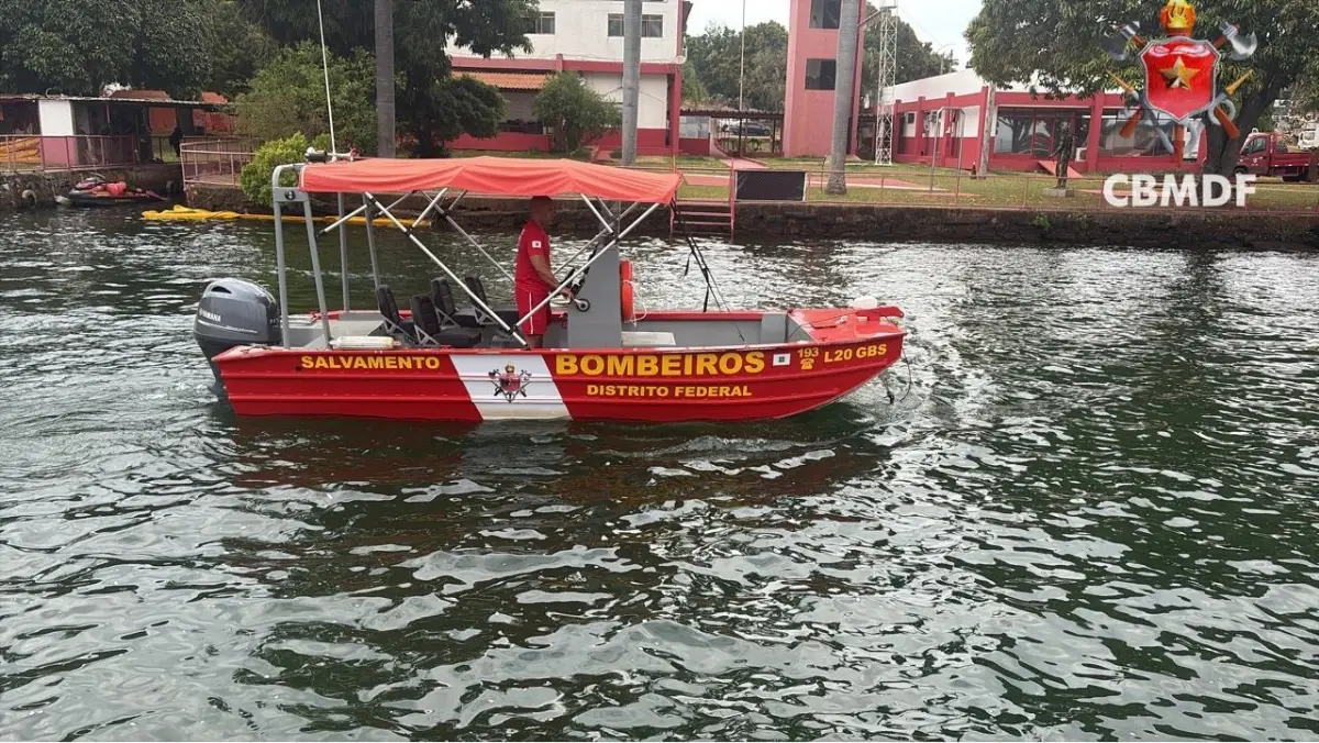 Bombeiro militar pilotando embarcação de salvamento e resgate do CBMDF de cor vermelha e branca na água.